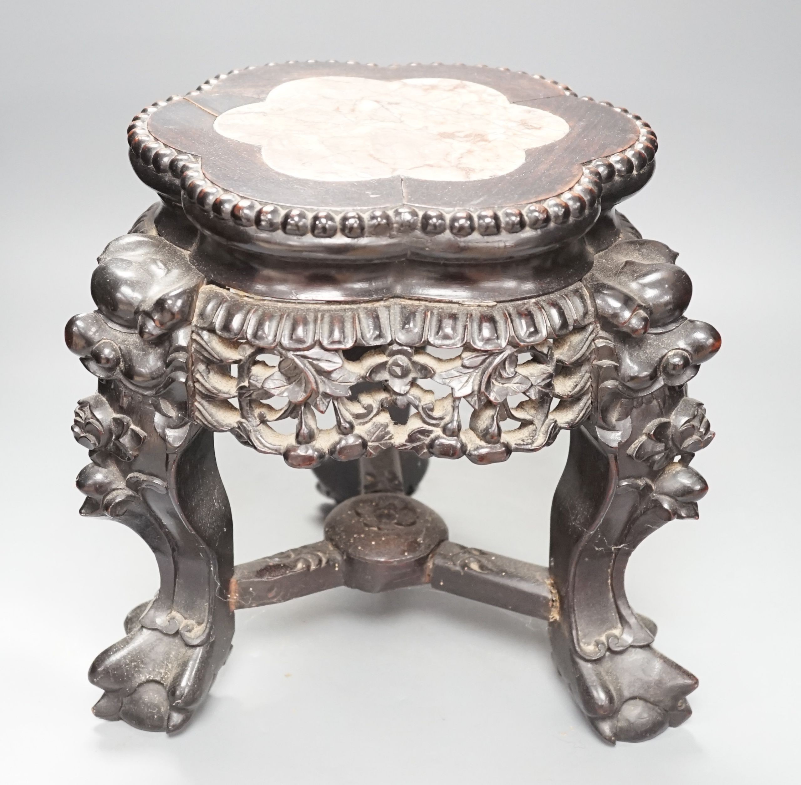 AChinese carved wood jardiniere stand, late Qing dynasty, with hard stone inset, top 26 cms diameter.
